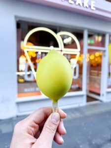 Customer enjoying Snow Lemon gelato stick outside Snowflake Gelato store.