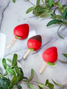 Row of Snow Berry strawberry-shaped gelato sticks by Snowflake Gelato with white chocolate shell
